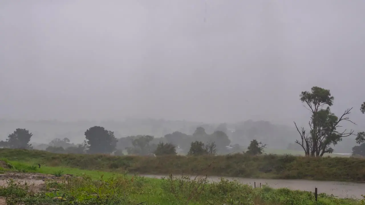 A time lapse of dark storm rain clouds rolling in across rural Australia countryside with rain and sun breaking through the clouds