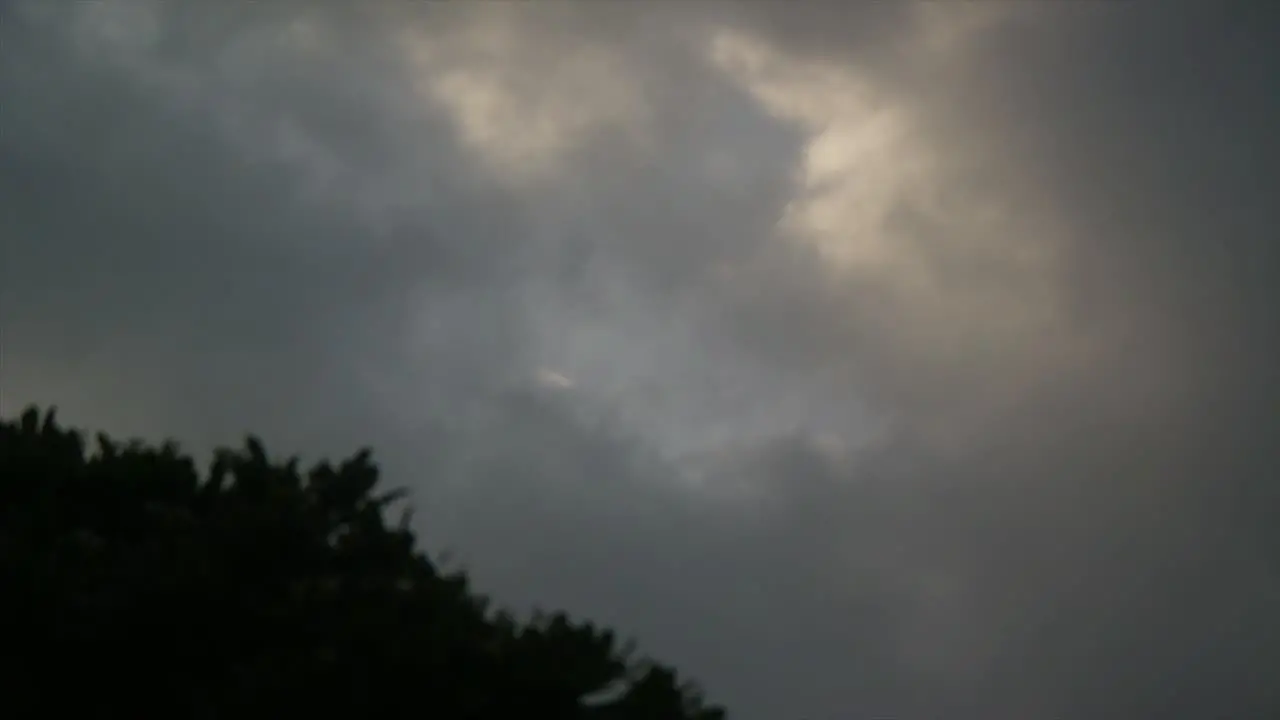 timelapse dark clouds in the sky with thunderstorm trees foreground