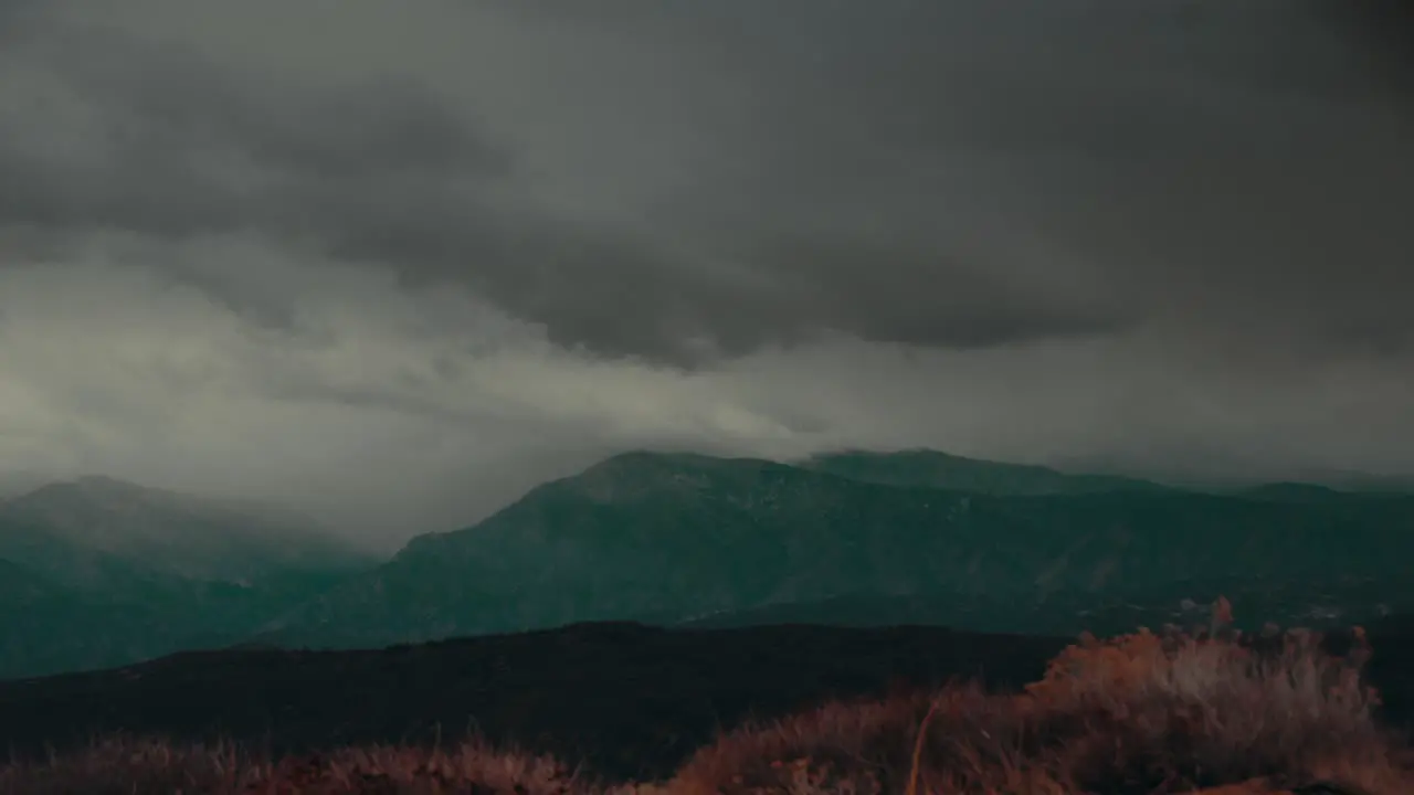 Time Lapse Storm Clouds Travel Over A Hillside And Mountains