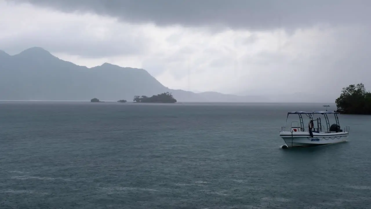 Moored dive boat during stormy grey cloudy and wet rainy day during monsoon season in Coron Bay of Palawan Philippines