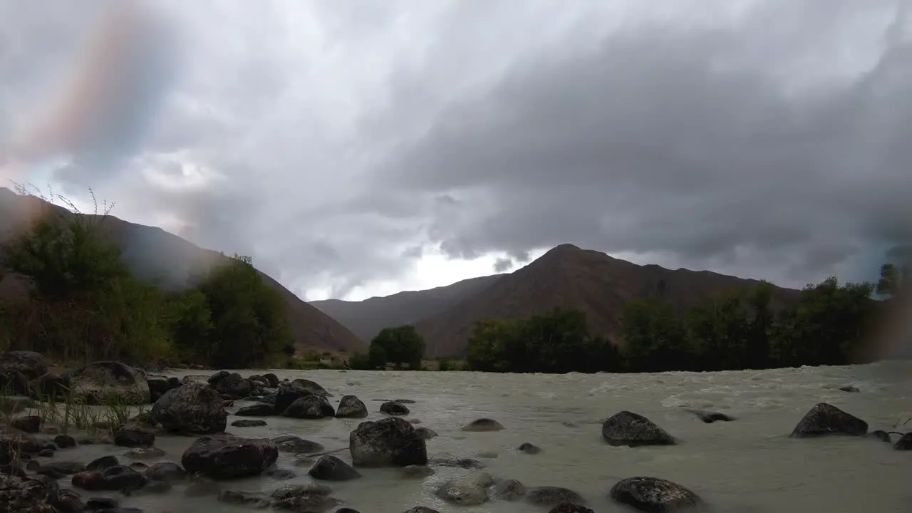 Timelapse of storm over mountains dirty river and range