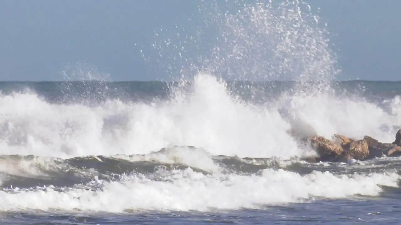 Stormy seas breaking on rocks slow motion seascape