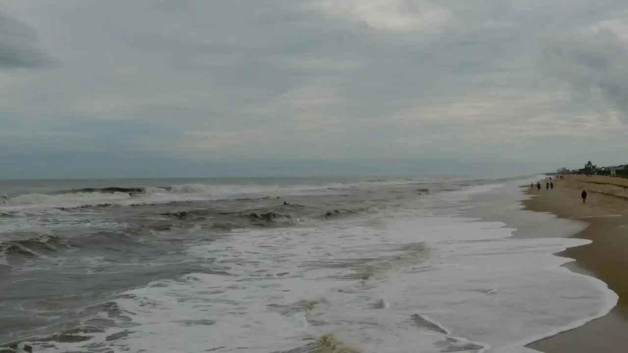 Aerial shoreline slow motion shot with big waves on a cloudy day