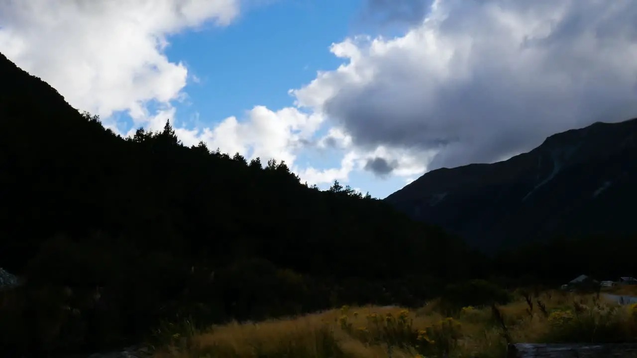 timelapse of cloudy rolling over forest mountains in shadow