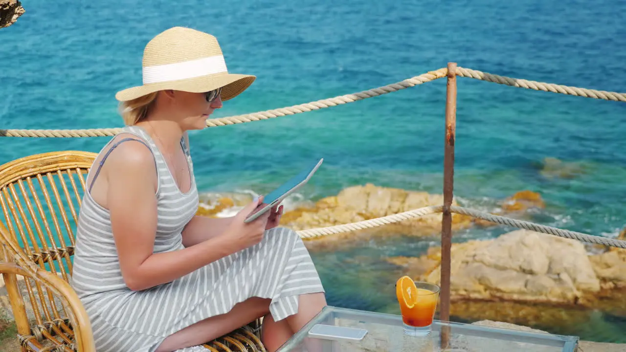 Business Woman On Holiday Sitting In A Cafe With Scenic Views Of The Sea It Works With Tablet