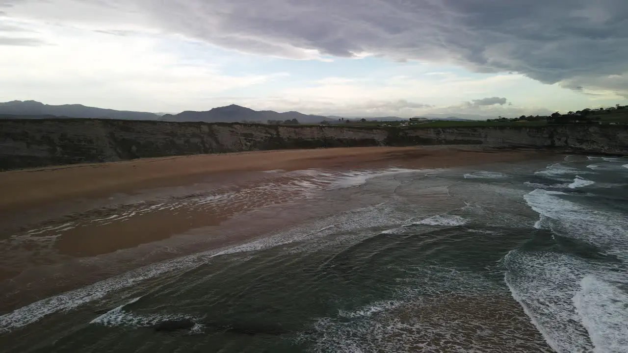 Ocean waves crashing to rocky beach cliff at Cantabrian sea coastline