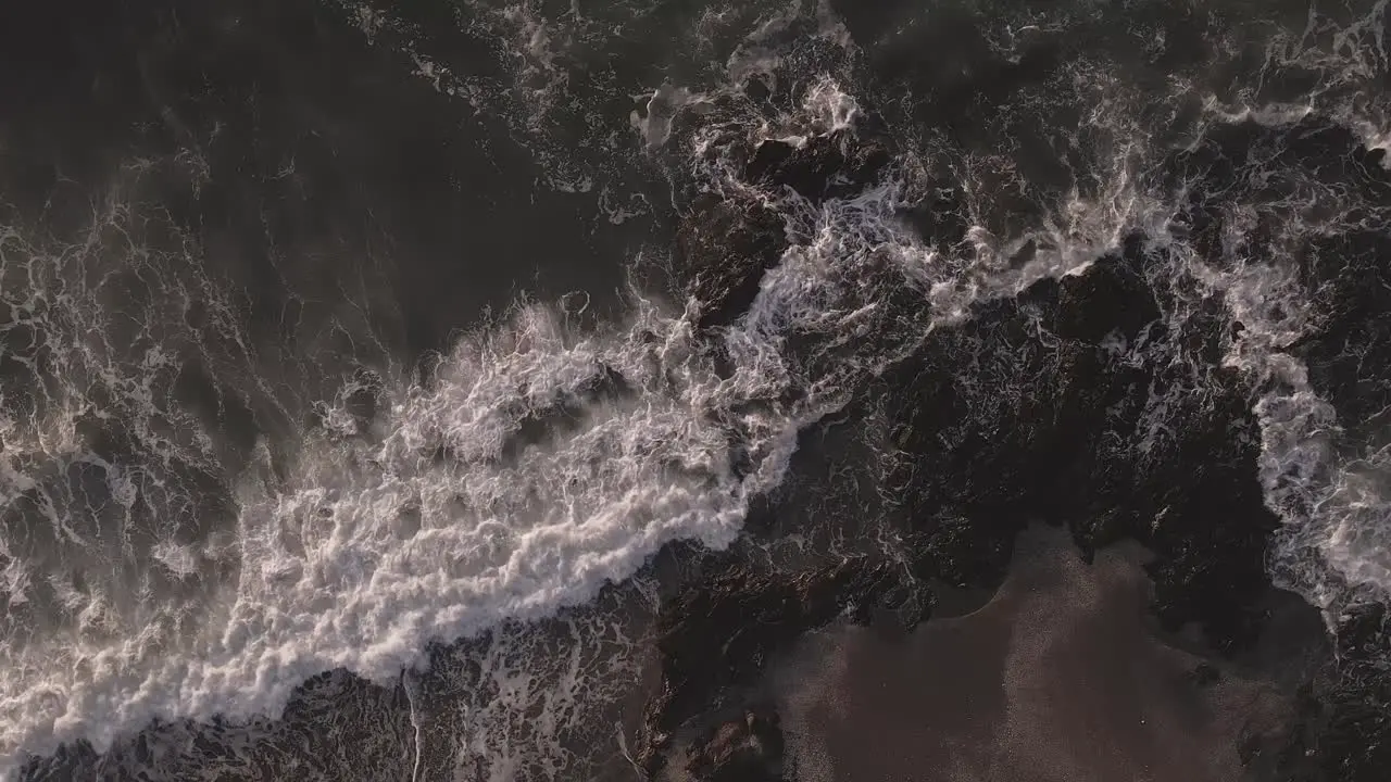 Aerial view birds eye perspective overlooking slow motion foaming ocean waves scene