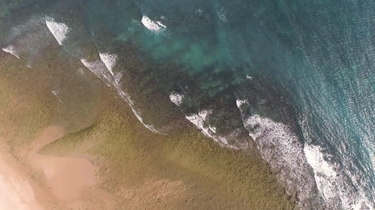 Aerial Top down view of waves splashing against the coast