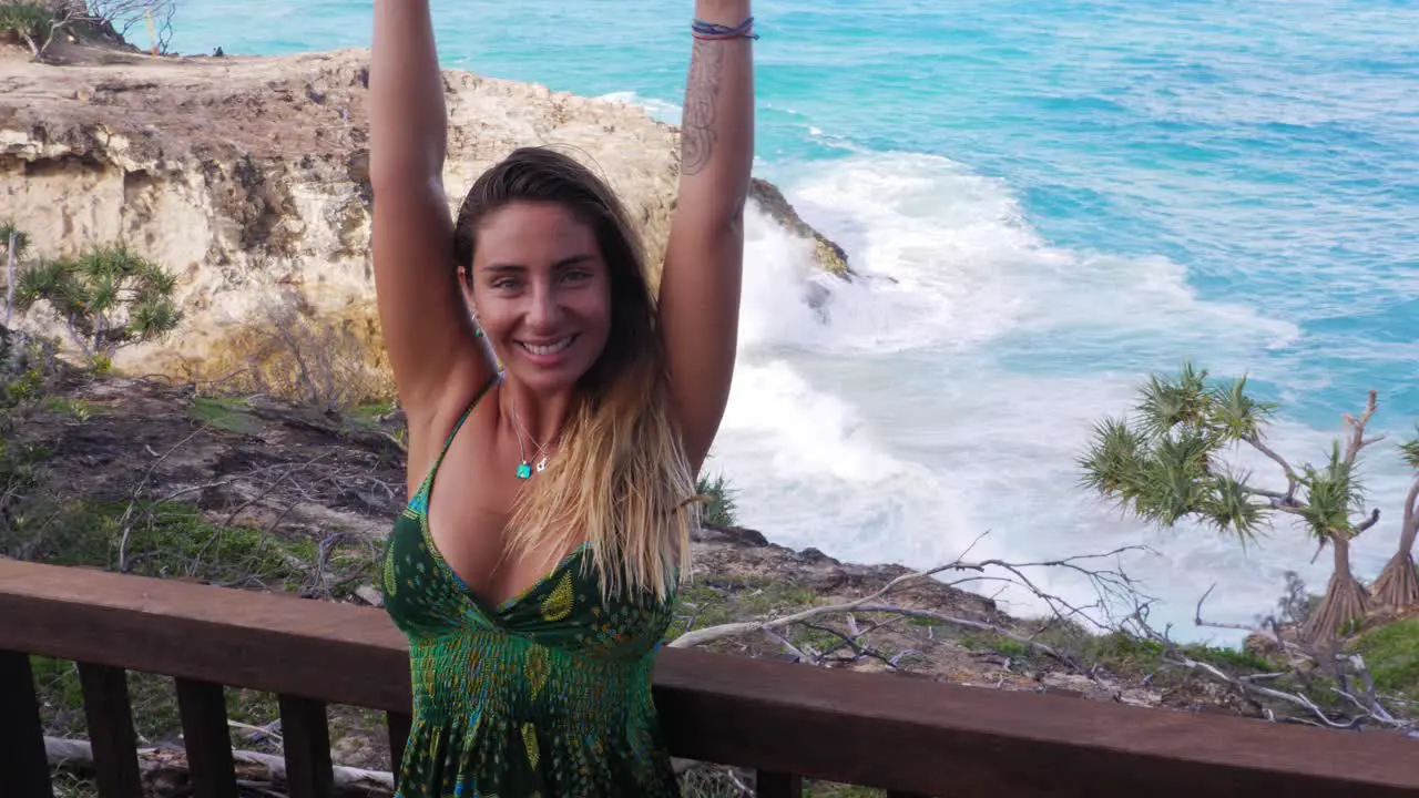 Happy Woman Raising Both Hands With Crashing Waves In Background North Gorge Walk In Point Lookout QLD Australia