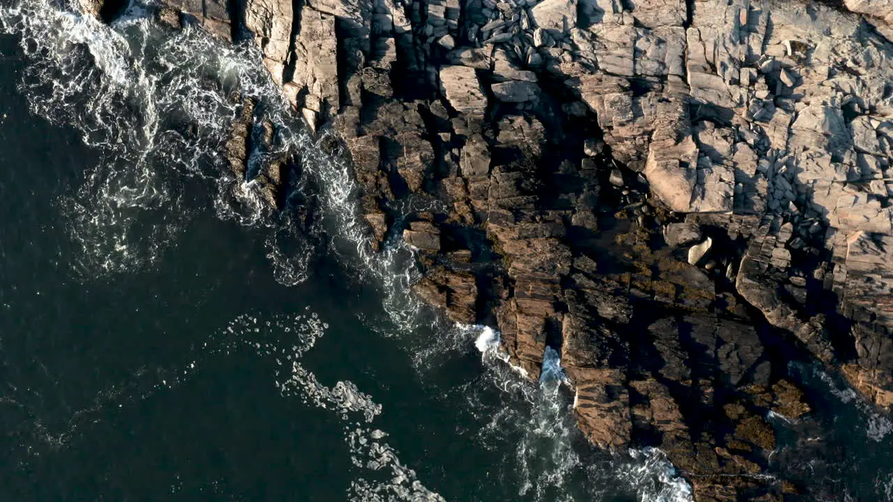 Breath taking aerial bird's eye view of waves crashing on the coast of Maine