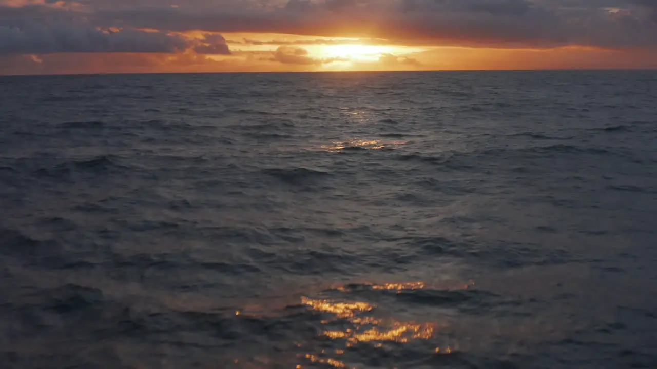 Twilight shot of golden sunset on the ocean Aerial dolly shot of beautiful orange sunset on deep blue sea