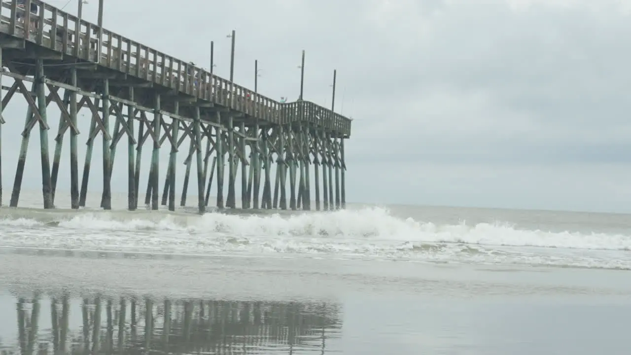 Waves crashing in slow motion under Ocean isle pier