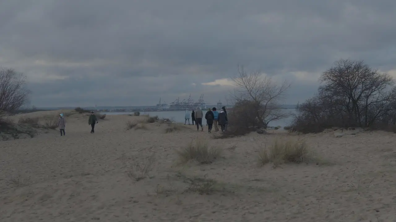 People walking on beach near Górki Zachodnie in Gdańsk direction view harbor in Gdańsk