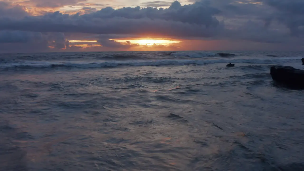 Retreating view of waves on the ocean during sunset Sea waves on a rocky shore in beautiful warm evening light