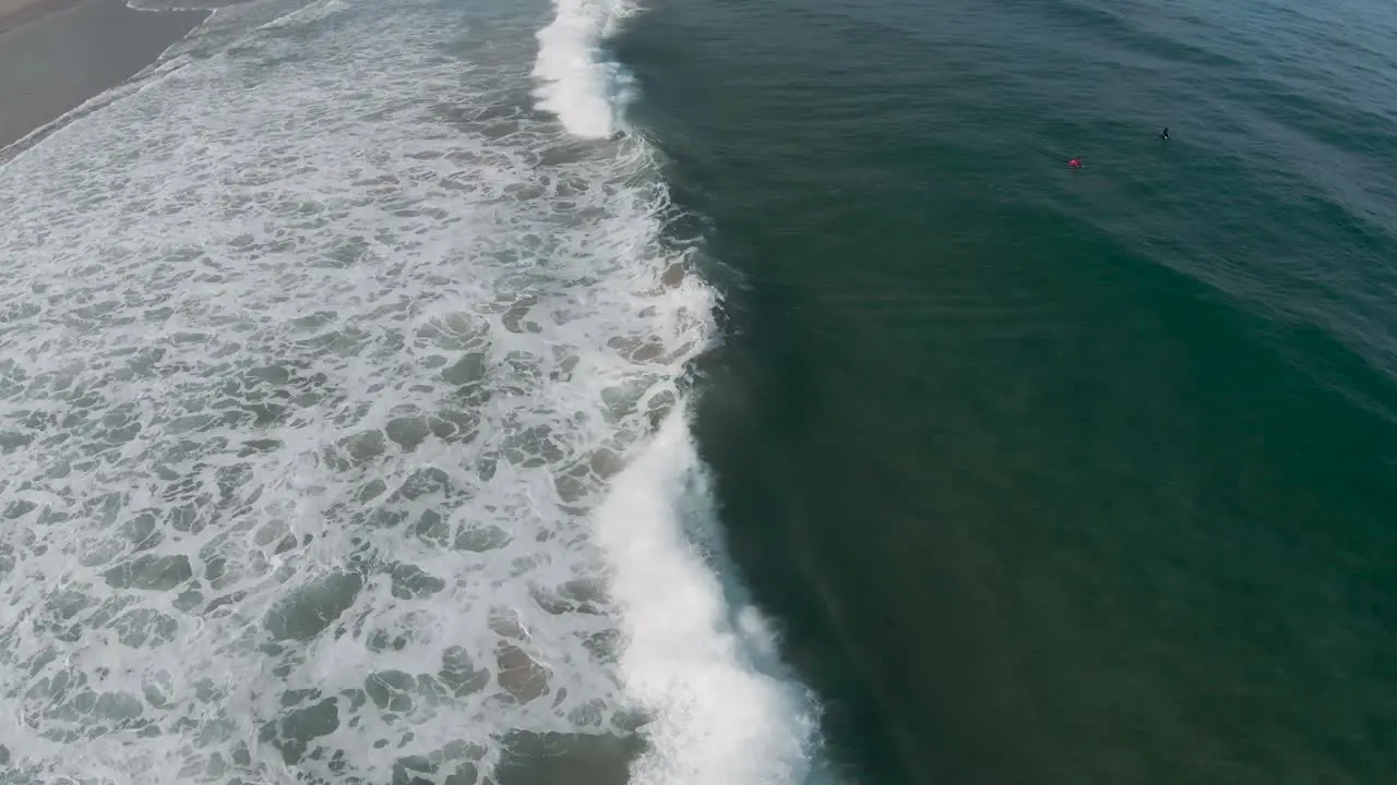 Powerful ocean waves crash in impact zone as ocean spray dances off the top