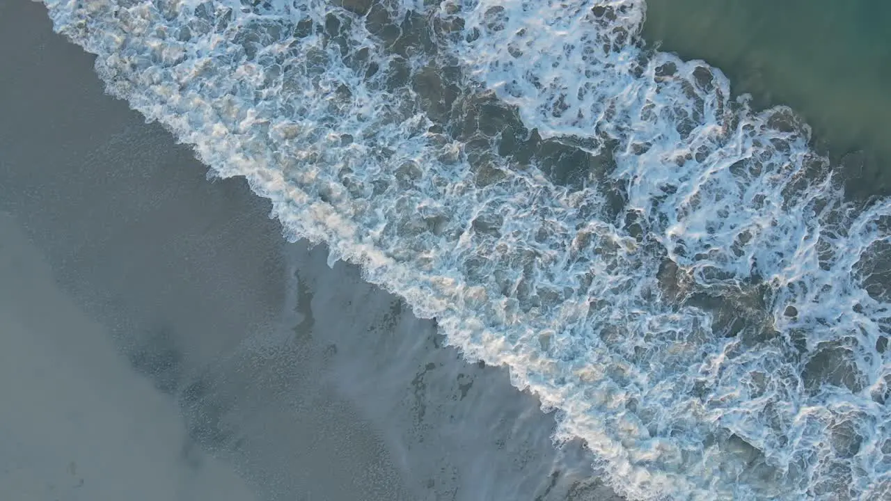 UAE Aerial view of waves breaks on the beach Bird's eye view of ocean waves crashing and foaming against the empty shore rough sea view