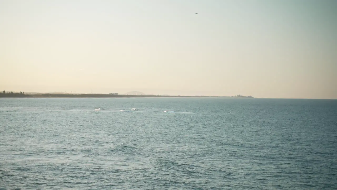 Beach Shore Coastline At Sunset With Small Plane Flying Over Horizon In Distance 4K