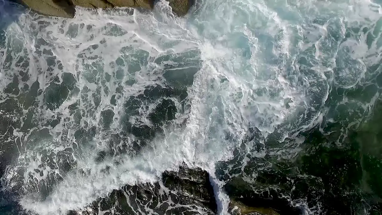 Slow motion Aerial Waves Breaking On Rocks steady close up slow