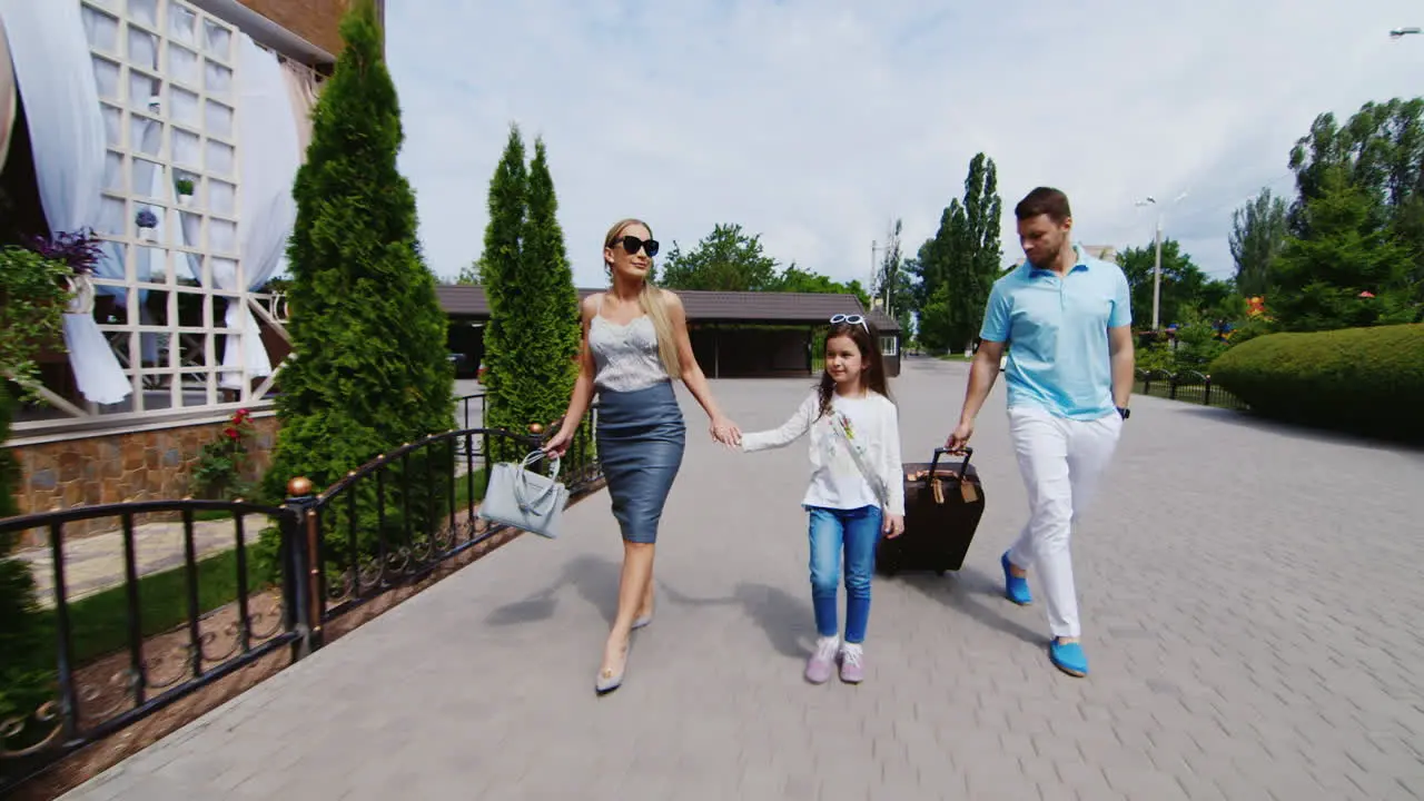 A Young Family With A Child and Suitcases