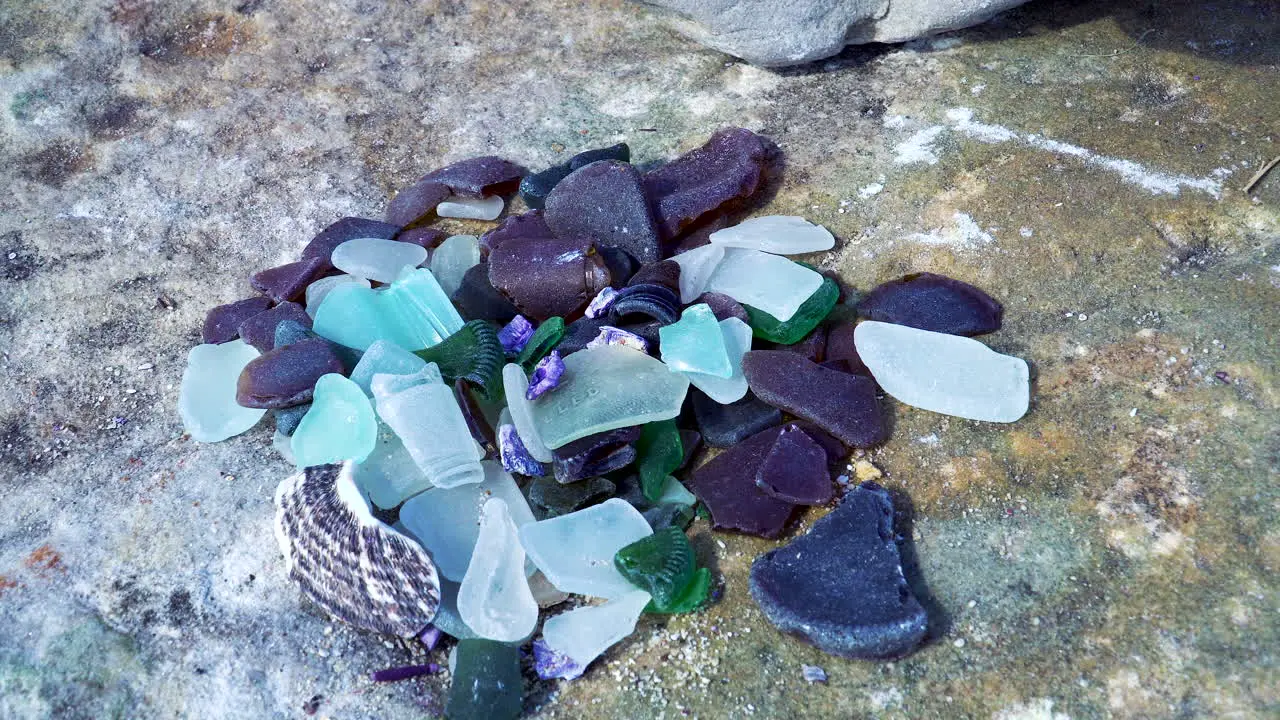 close up multiple colored pieces of ocean glass at beach