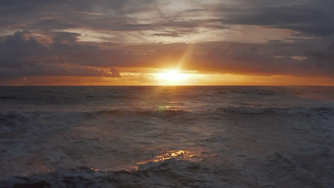 Small sea waves crashing ashore with beautiful golden sunset in the background Ocean waves in the stunning evening light