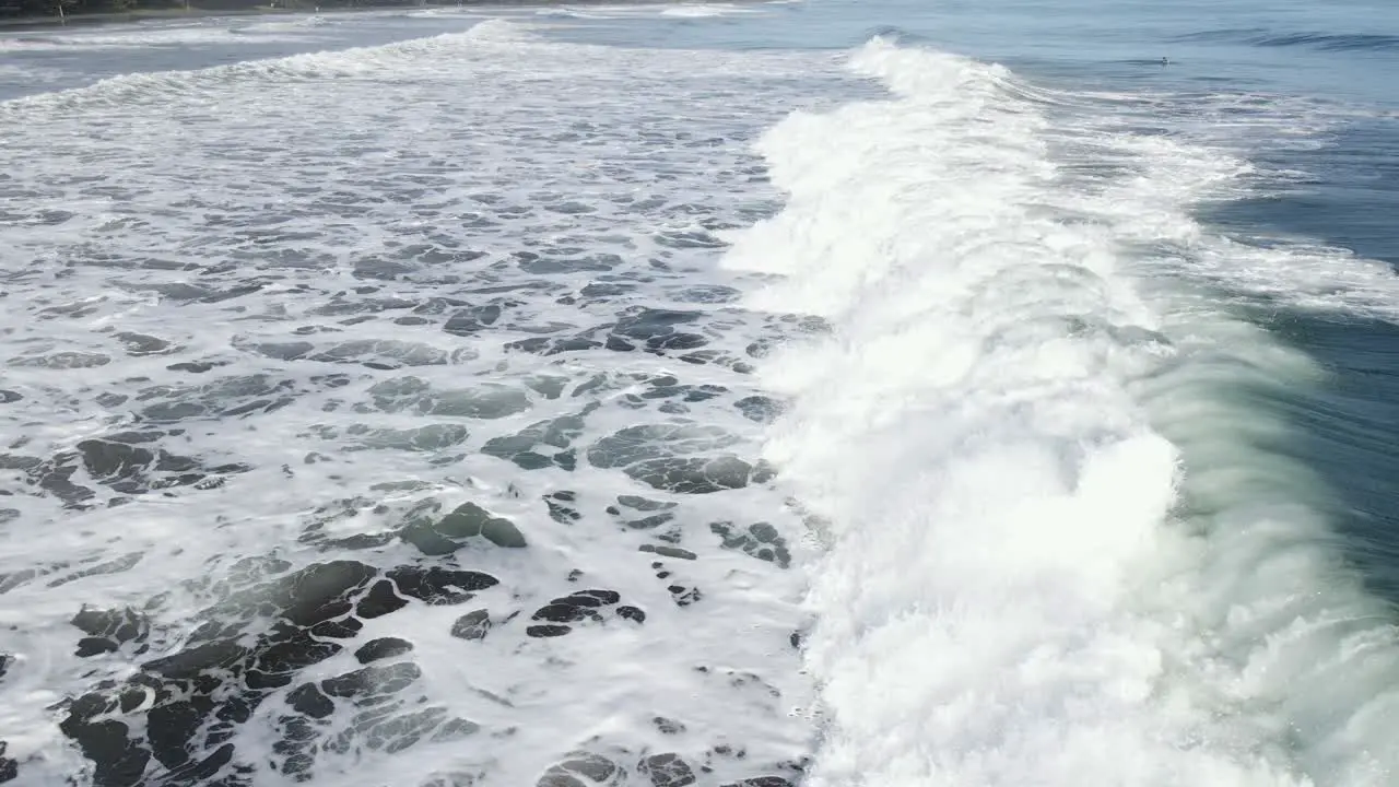 Aerial close up of deep blue wave crashing in the ocean