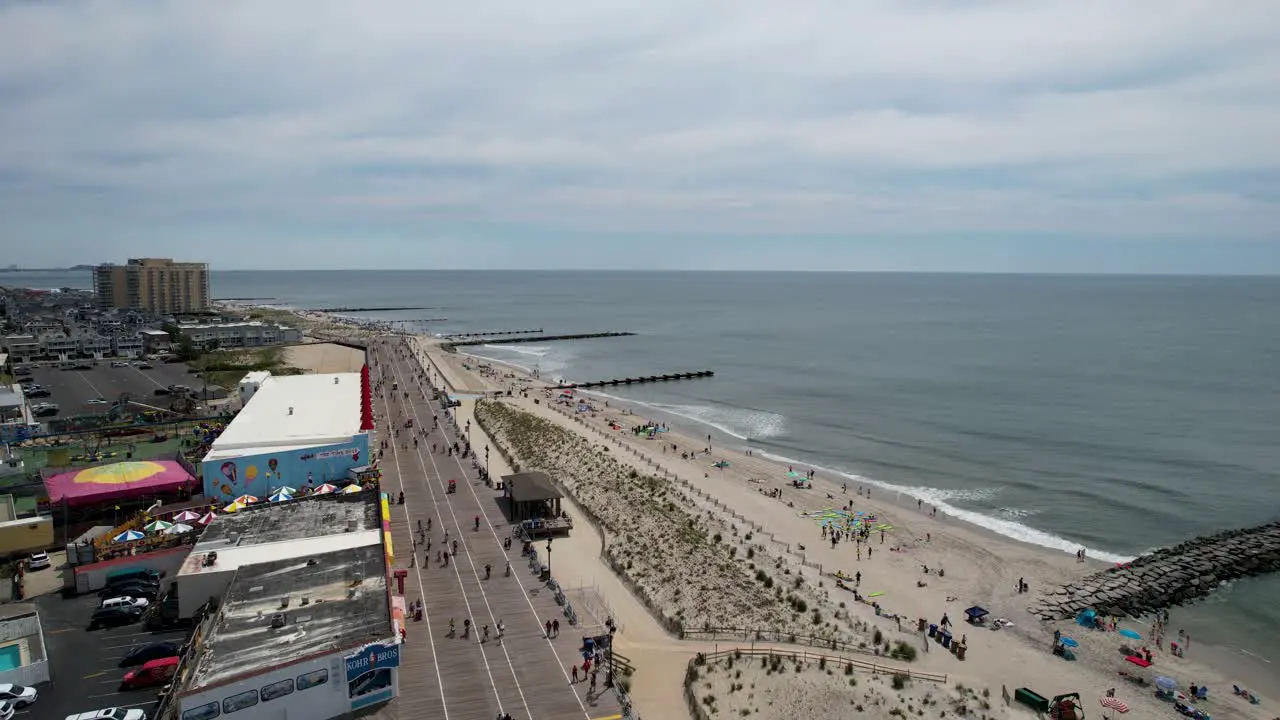 Aerial shot over a Jersey Shore boardwalk with waves crashing on the beach