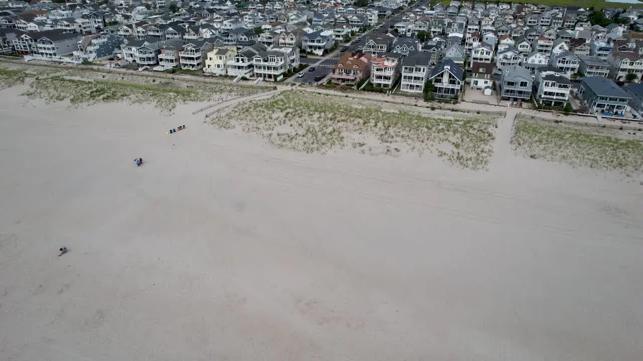 Drone shot flying from the ocean to the beach houses at the New Jersey shore