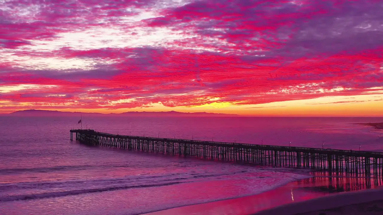 An astonishing sunset aerial shot over a long pier and the Pacific Ocean and Channel Islands in Ventura Southern California