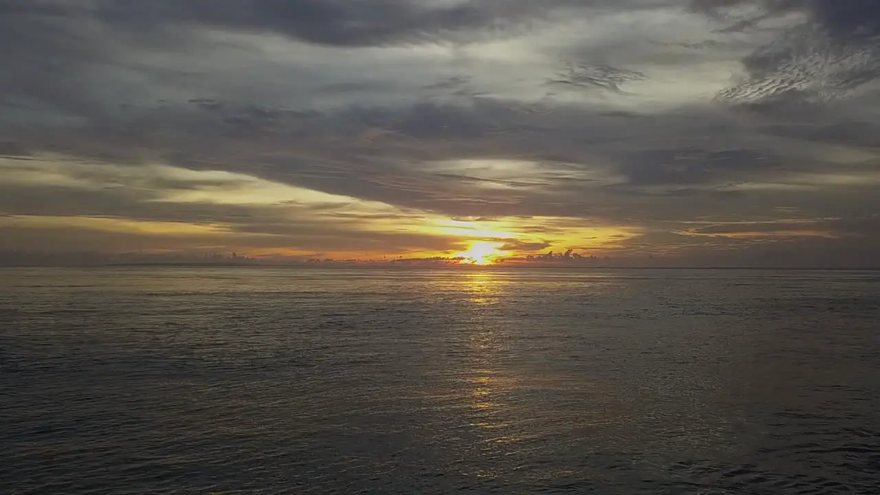 Dramatic golden sunset cloud sky over textured ocean