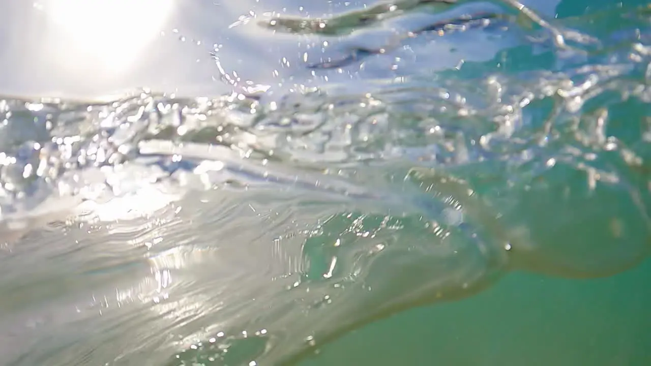 Blue Water From Ocean Swell Splashing Onto Camera Lens In Summer