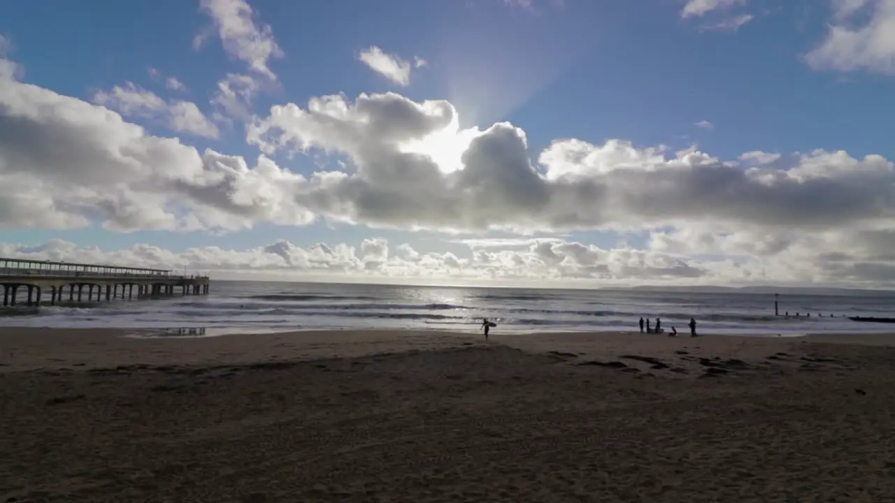 A lone surfer walking towards the camera