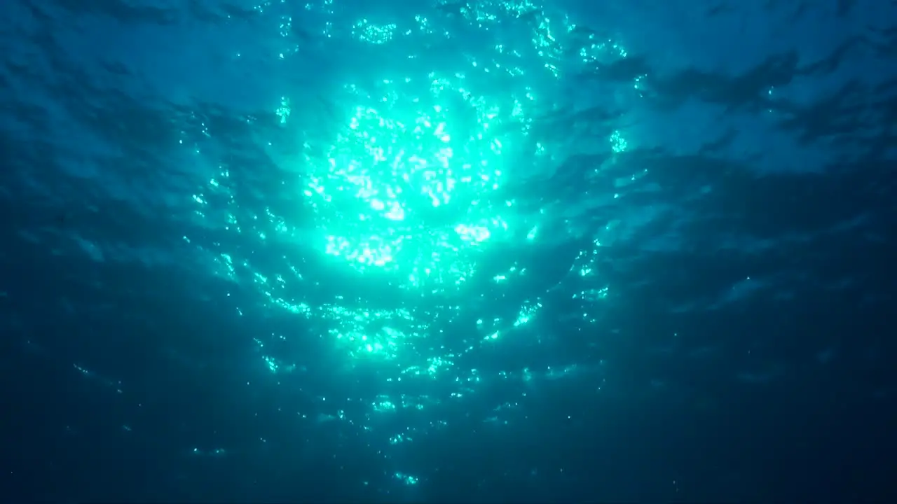 Sun shining through ocean surface filmed from underneath the surface