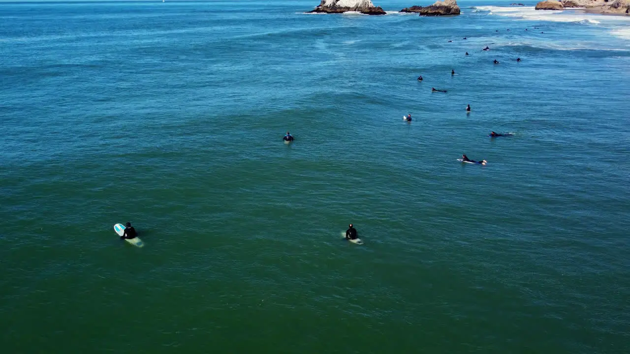 Aerial View Of Surfers Lying On Surfboard Waiting For Waves To Surf