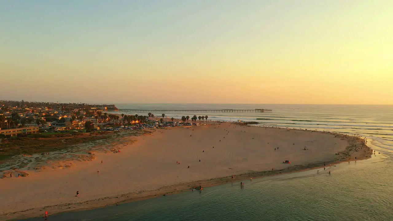 Drone circles around dog beach in Ocean Beach San Diego California at sunset