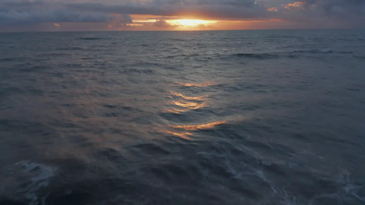 Aerial dolly shot of blue sea waves during golden sunset Orange and blue evening shot of waves at sea