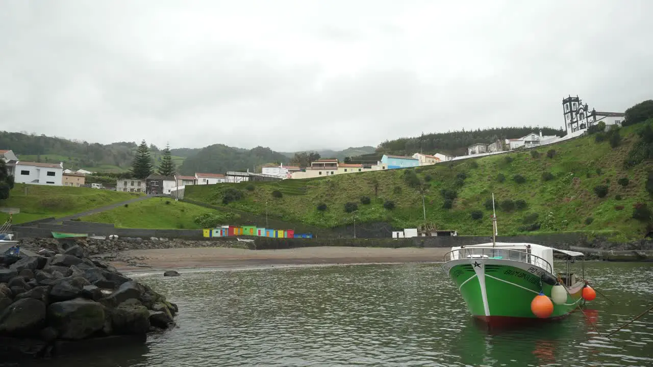 green boat in the water porto formoso harbor azores