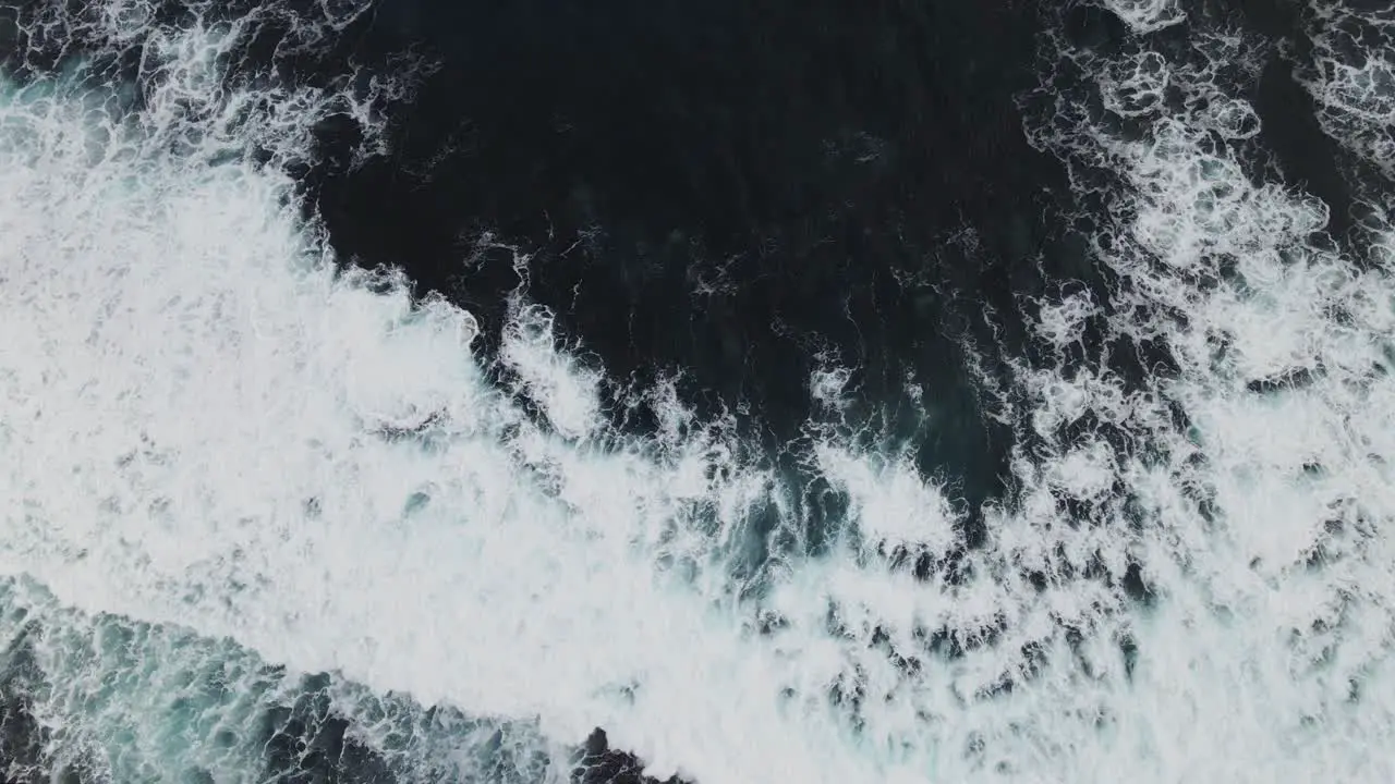 aerial shot of waves crashing in the ocean with ocean spray and whitewash