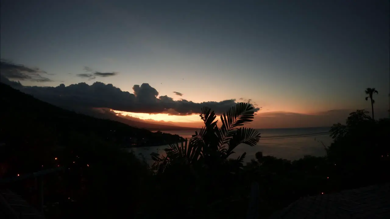 Tropical sunset time lapse to darkness over ocean cliff as light fades away gently