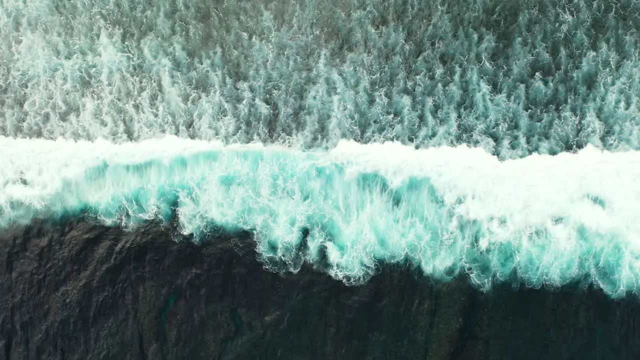 Big ocean waves splashing and foaming on seashore creating abstract beautiful texture of dramatic motion copy space top down view