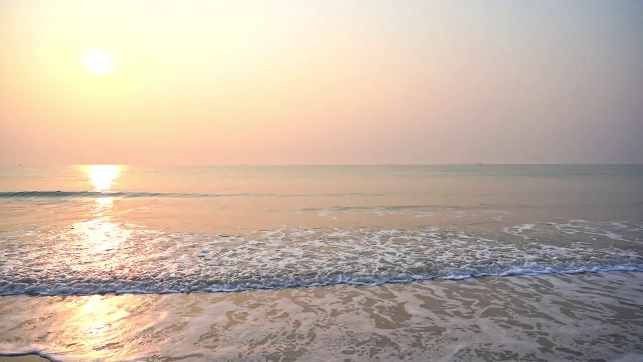 Close-up of waves spreading out over a beach at sunset