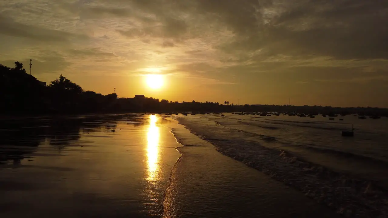 Aerial flyover calm beach shore early morning during golden paradise sunrise