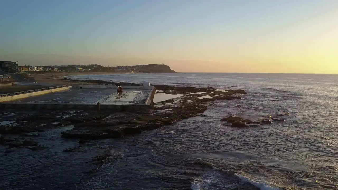 Mereweather Ocean Baths pool being cleaned by tractor at sunrise