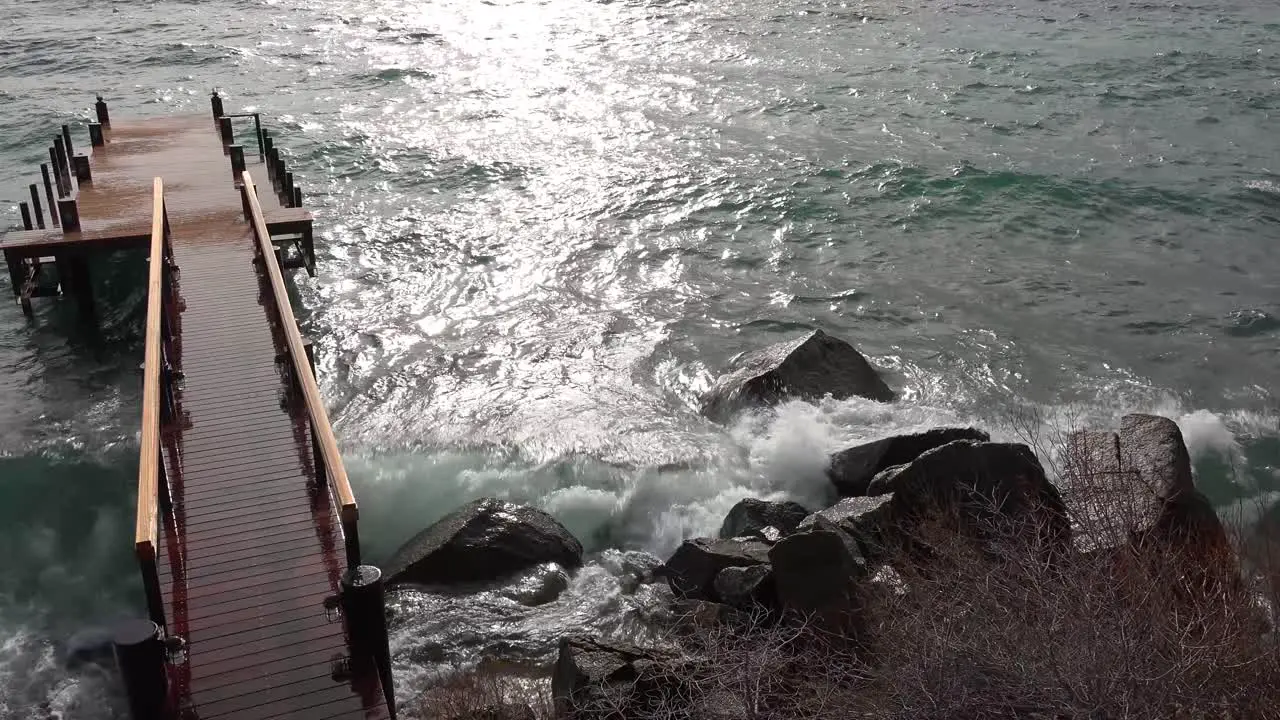 Huge waves crash into a pier and shore on the banks of Lake Tahoe during a big winter storm