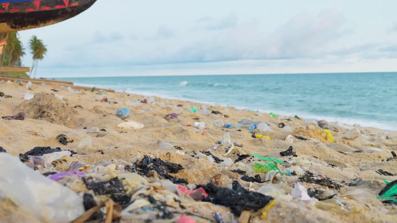 Established of marine pollution plastic bottle waste and bags on tropical sand beach with ocean sea waves on background