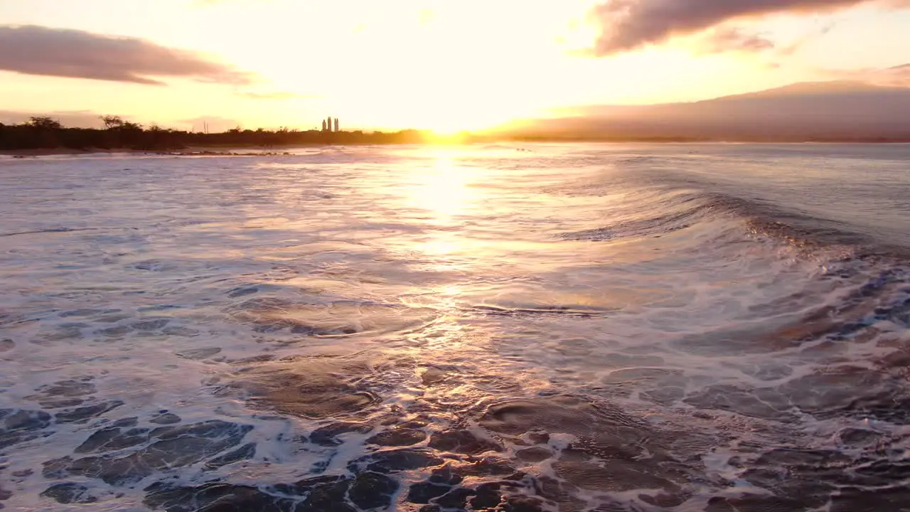 static aerial shot of big waves in maui hawaii during sunrise with ocean spray