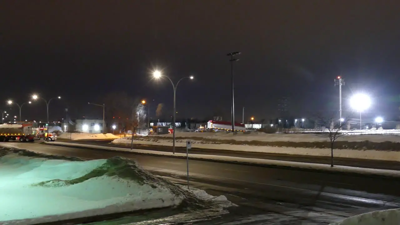 Pan of city streets with busses and semi trucks passing night