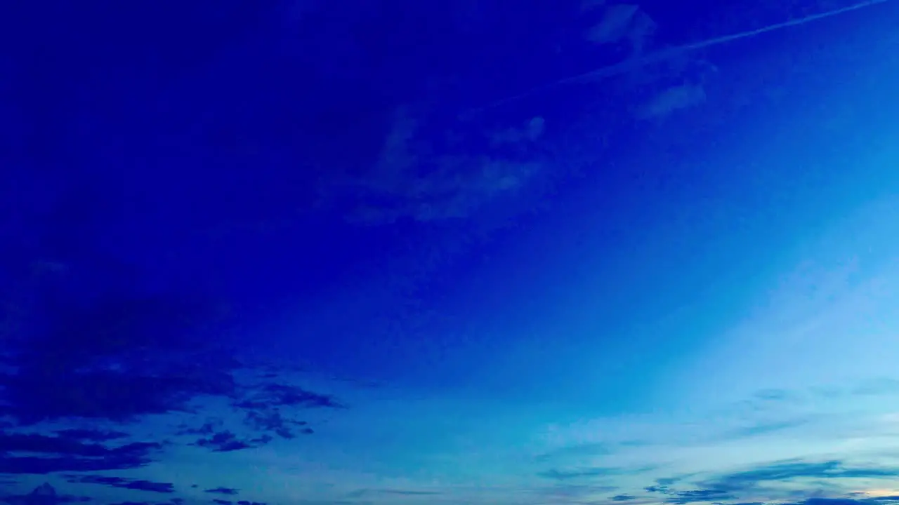 Drone shot looking down in a sweeping pan shot against a dusk sky with a long highway with vehicle plying upon