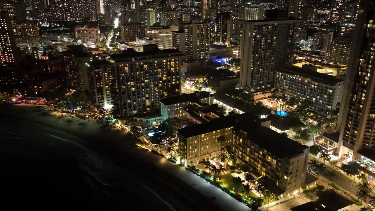 aerial drone timelapse of waikiki strip at night with hotels and city lights with traffic in honolulu hawaii