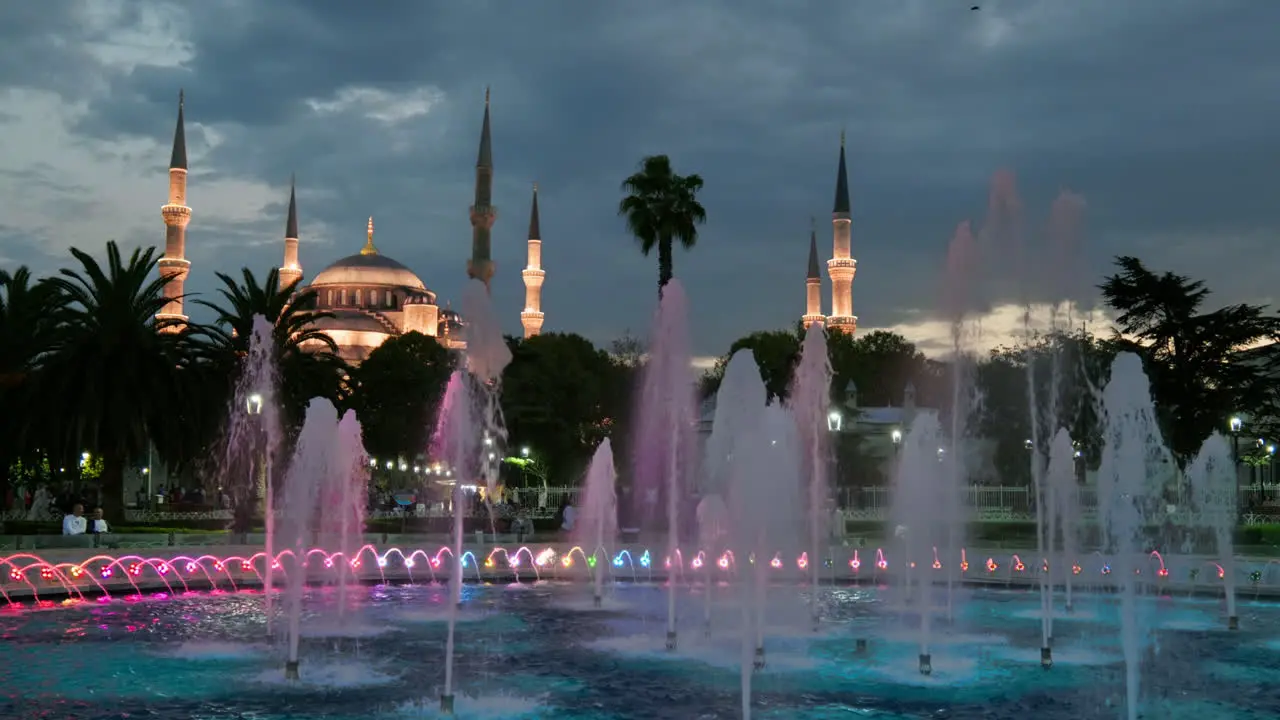 Blue mosque Sultanahmet illuminated at night and colourful water fountains